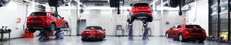 Mazda vehicles in a service bay on lifts
